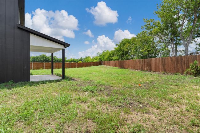 Fenced backyard with a patio | Image 38