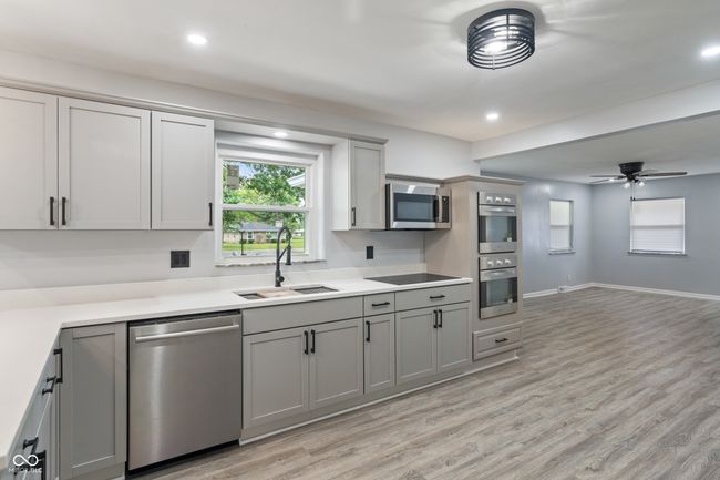 kitchen with stainless steel appliances, a sink, gray cabinetry, light wood-style flooring, and recessed lighting | Image 12