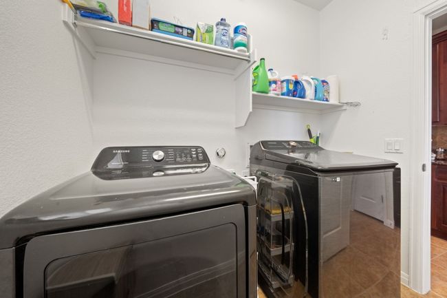 Washroom featuring separate washer and dryer and light tile patterned flooring | Image 24