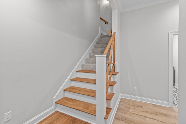 Staircase featuring wood finished floors and crown molding | Image 21