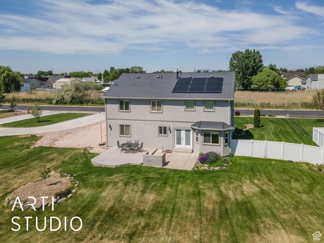 Rear view of property featuring french doors, a patio area, roof mounted solar panels, stucco siding, and roof with shingles | Image 48