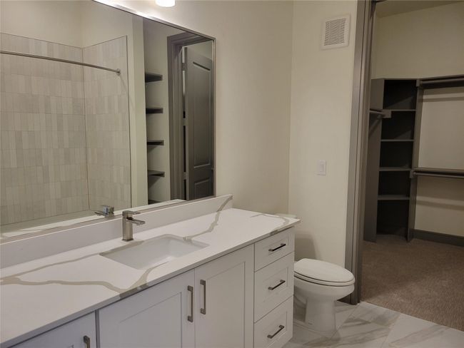 Bathroom featuring vanity, toilet, and a tile shower | Image 12