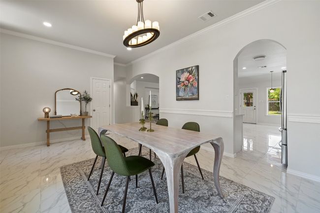 Formal Dining area with light marble finish floors, arched walkways. | Image 7