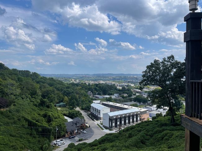 Behold the captivating vista of downtown Chattanooga from the pool deck! From this vantage point, you can admire the lush trees below and the picturesque blue-painted bridge spanning the serene Tennessee River in the distance. | Image 39