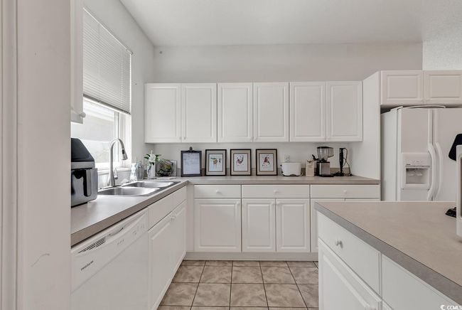 Kitchen featuring white appliances, a sink, light countertops, and white cabinets | Image 14