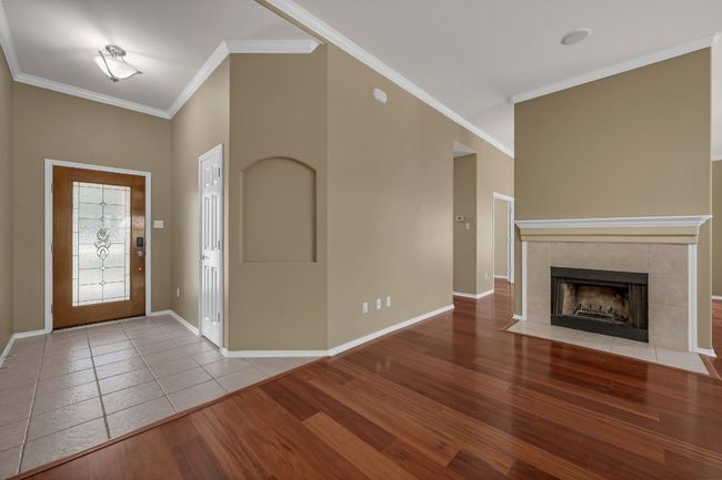 This elegant residence features a welcoming stone patio entry and stunning glass front door, setting the tone for the warmth and character found throughout. | Image 6