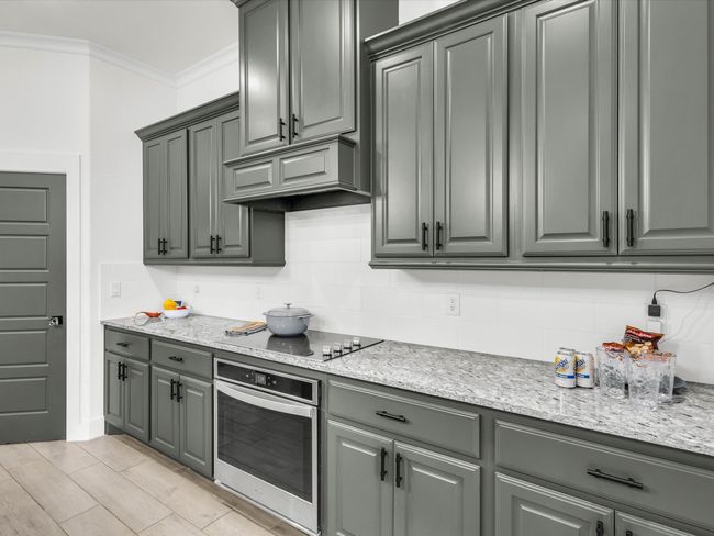 Custom vent hood, stainless steel appliances, and a spacious walk-in pantry. | Image 9