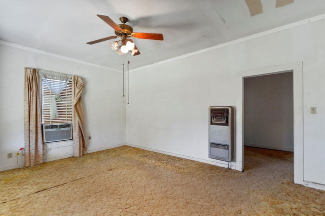 Empty room featuring cooling unit, crown molding, heating unit, and ceiling fan | Image 7