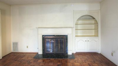 Living room as you enter to the right. Gas or wood burning fireplace with mantel. Parquet flooring. Built in hutch with adjustable shelves and cabinet below. Window opposite of fireplace faces the front of the home. Note: Each fireplace has it's own chimney | Image 2