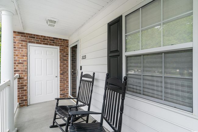 Doorway to property with covered porch and brick siding | Image 9
