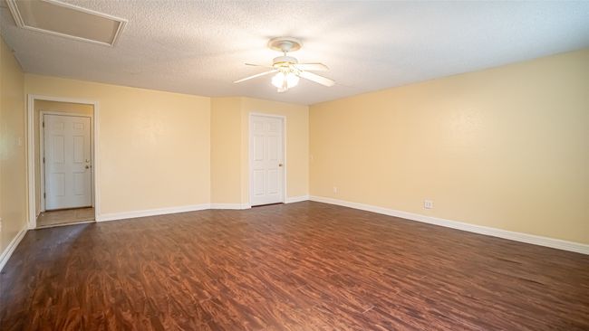 Unfurnished room featuring dark wood-style flooring, ceiling fan, baseboards, and a textured ceiling | Image 20