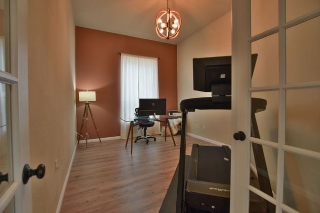 Workout room featuring baseboards, lofted ceiling, a chandelier, and wood finished floors | Image 21