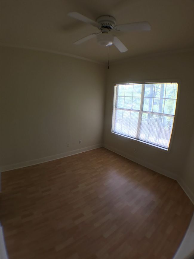Unfurnished room featuring ceiling fan, baseboards, crown molding, and wood finished floors | Image 10