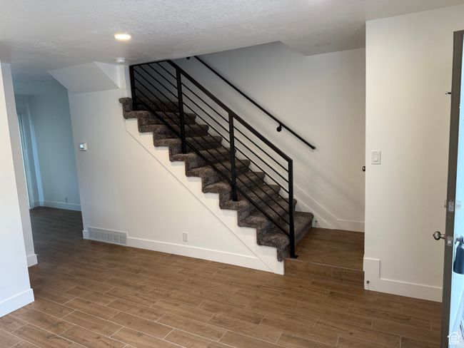 Staircase with visible vents, baseboards, and wood finished floors | Image 6
