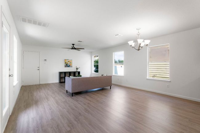 Thanks to plenty of windows, natural light fills the main living area and bounces off the warm flooring. | Image 13