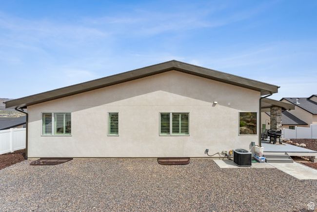 Rear view of property featuring fence, a wooden deck, stucco siding, and central air condition unit | Image 65