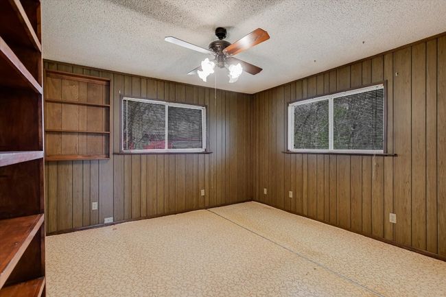 Spare room with a textured ceiling, a ceiling fan, and wooden walls | Image 8