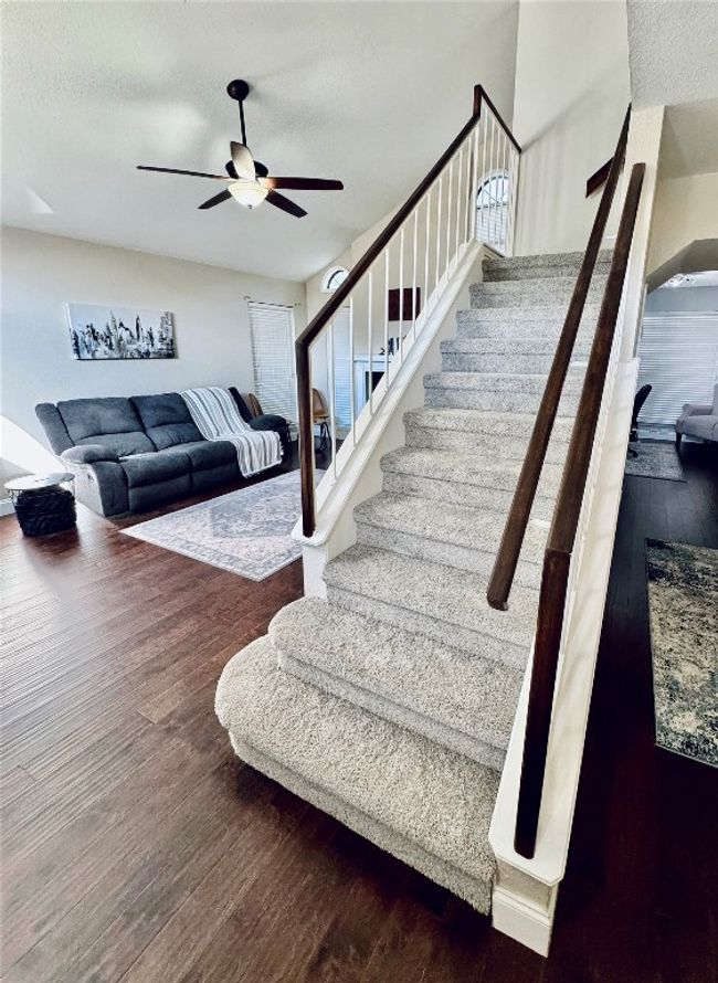Stairway featuring a ceiling fan and wood finished floors | Image 4