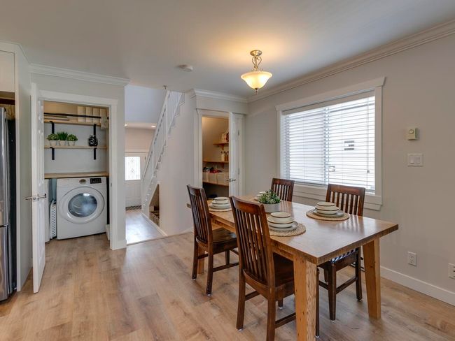 Dining area featuring light wood finished floors, a wealth of natural light, stairs, and washer / clothes dryer | Image 10
