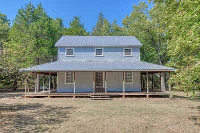 Farmhouse with a front lawn and covered porch | Image 1