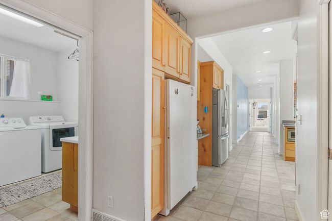Hall featuring light tile patterned floors, recessed lighting, washer and dryer, and baseboards | Image 9
