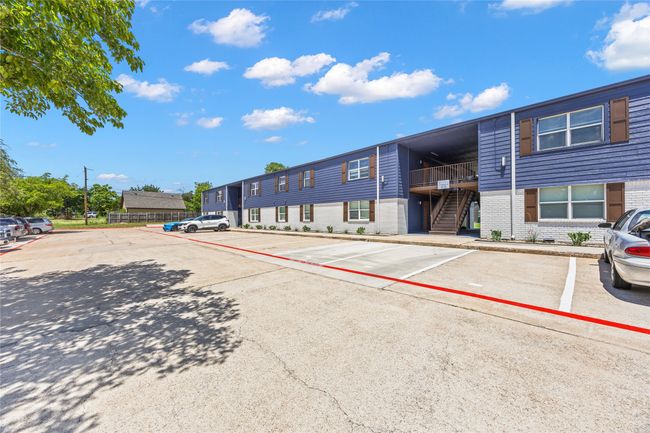View of property featuring stairway and uncovered parking | Image 9