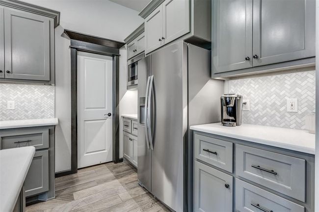 Kitchen with decorative backsplash, stainless steel fridge, and gray cabinets | Image 30