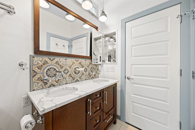 Bathroom with decorative backsplash, double vanity, and tile patterned floors | Image 20