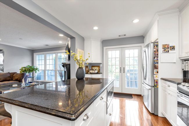 Kitchen featuring appliances with stainless steel finishes, light wood finished floors, white cabinetry, and visible vents | Image 6