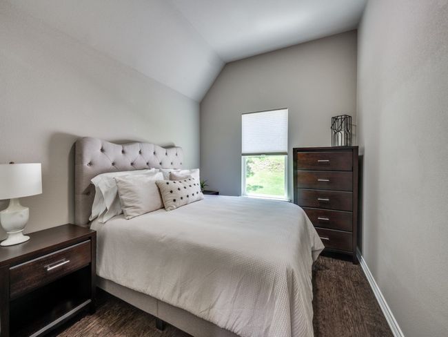 Bedroom with dark wood-type flooring, lofted ceiling, and baseboards | Image 15