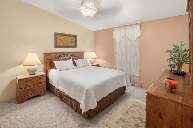 Bedroom with light colored carpet and lofted ceiling | Image 28