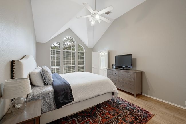 Primary Bedroom on the main level featuring light bamboo floors, lofted ceiling and full bath | Image 6