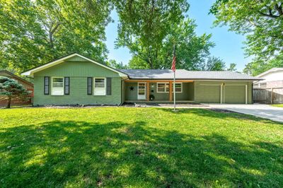 Ranch-style home featuring a garage and a front yard | Image 1