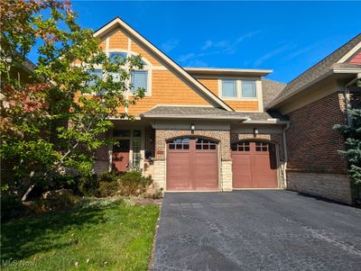 View of front facade featuring a front yard and a garage | Image 1