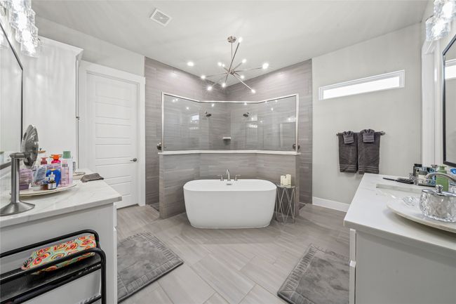 Bathroom featuring double vanity, a freestanding tub, walk thru tiled shower with 2 shower heads! | Image 16
