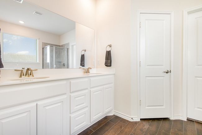 Full bath with a stall shower, double vanity, a sink, and wood finish floors | Image 18