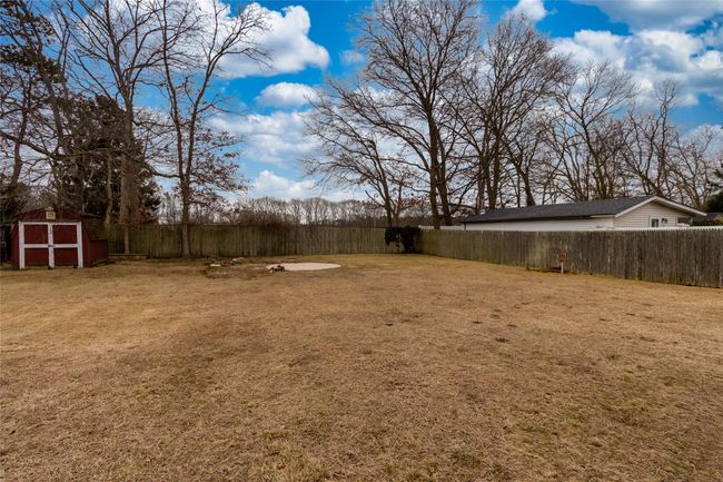 View of yard featuring an outbuilding, a storage unit, and a fenced backyard | Image 4