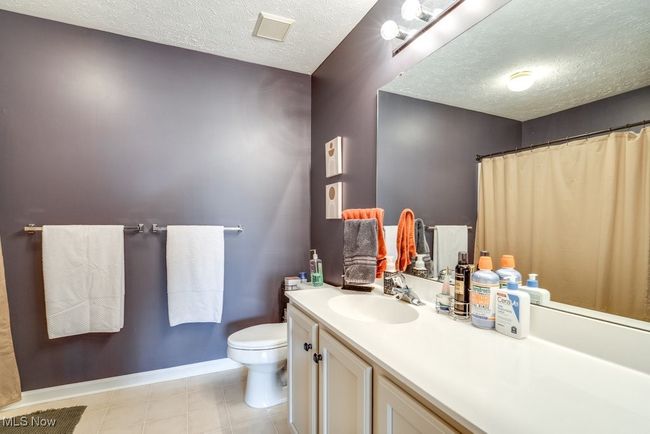 Bathroom with a textured ceiling and vanity | Image 32