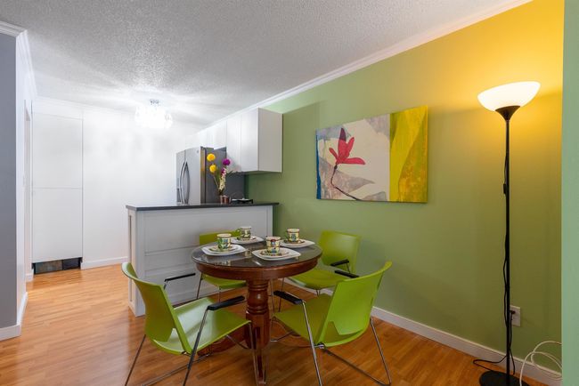 Dining area with baseboards, crown molding, a textured ceiling, and light wood finished floors | Image 7
