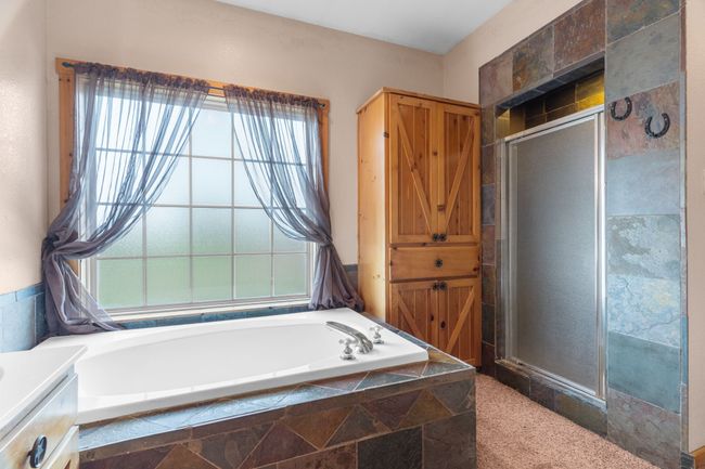 Bathroom featuring a shower stall and a garden tub | Image 36