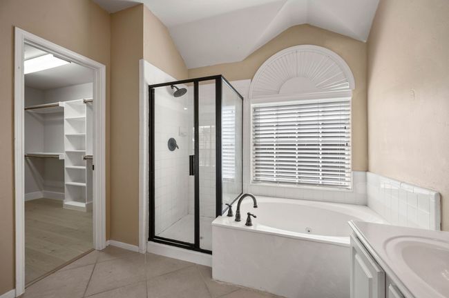Bathroom featuring a shower stall, tile patterned floors, lofted ceiling, and a bath | Image 24