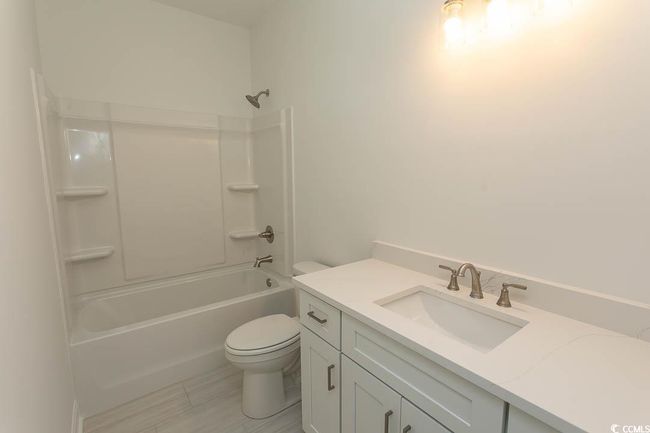 Full bathroom with toilet, vanity, and shower / bath combination located on first floor | Image 14