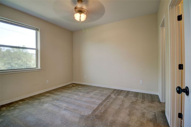 Unfurnished room with baseboards, ceiling fan, and carpet flooring | Image 9