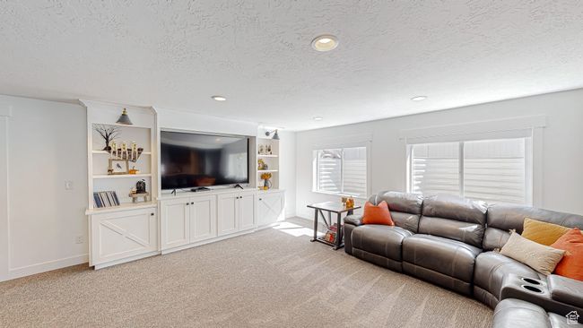 Living area featuring baseboards, a textured ceiling, and light carpet | Image 23