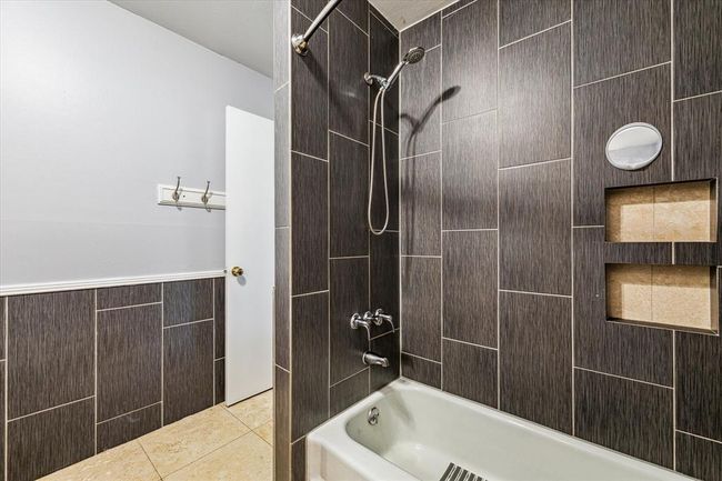 Another view of the third bathroom tub shower with inset shelving | Image 31