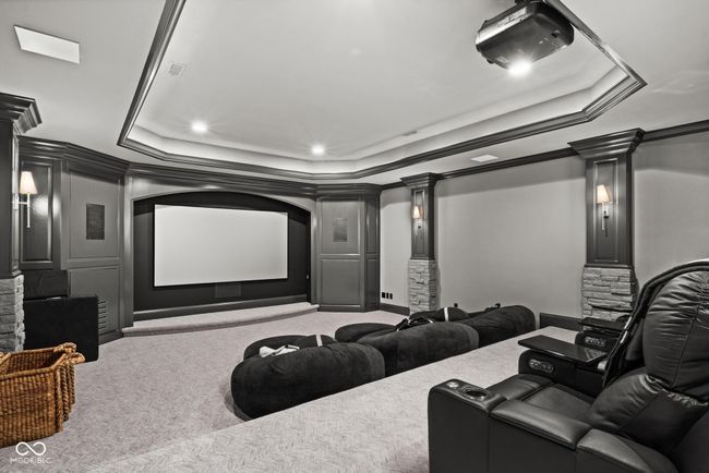 home theater room featuring a tray ceiling, carpet, decorative columns, crown molding, and recessed lighting | Image 89