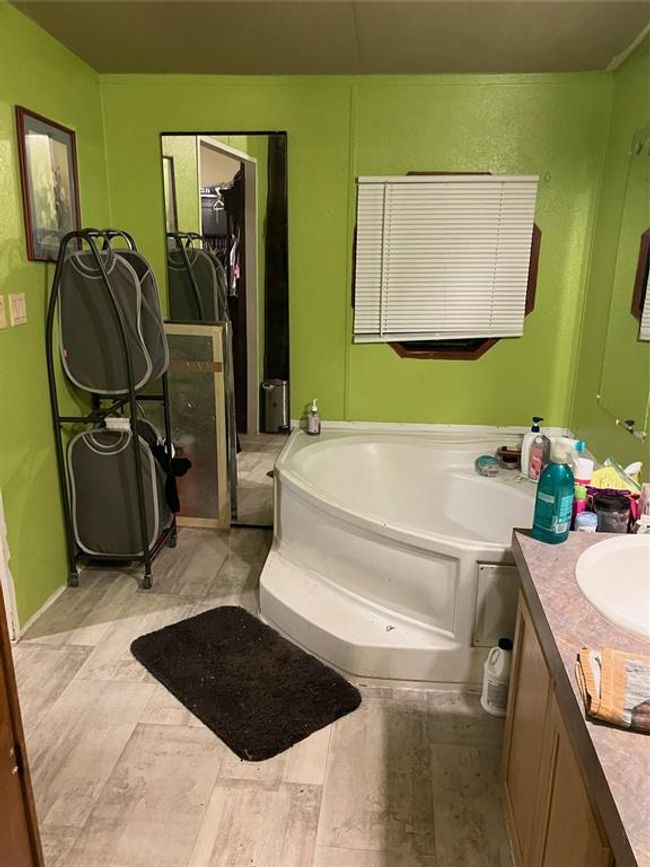Bathroom featuring vanity, tile patterned floors, and a bathing tub | Image 19