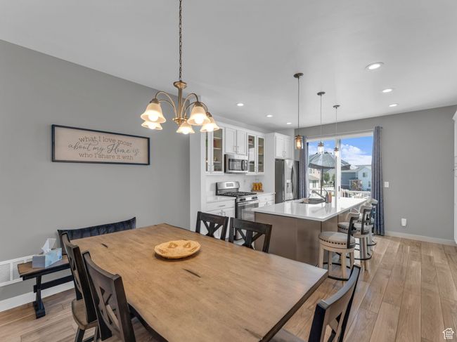 Dining room with light wood like finished floors, recessed lighting, and a chandelier | Image 14