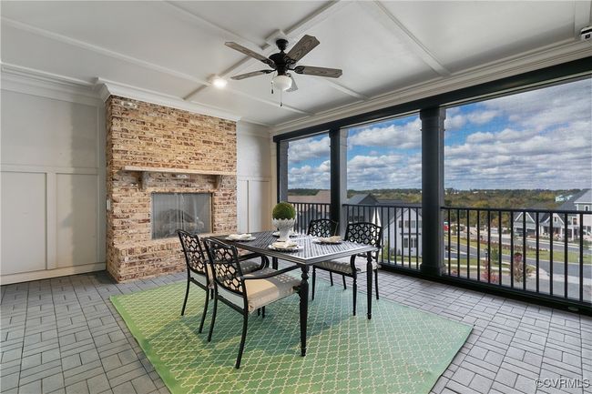 Sunroom featuring an outdoor brick fireplace and a ceiling fan | Image 33