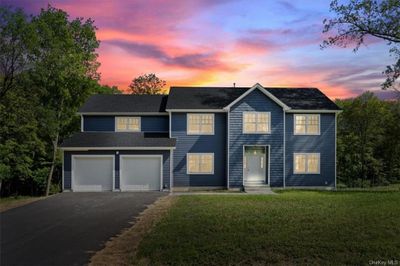 View of front facade with a lawn and a garage | Image 2